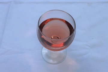 Verre de vin rosé dans un verre ballon transparent sur une nappe blanche - Département du Rhône - France