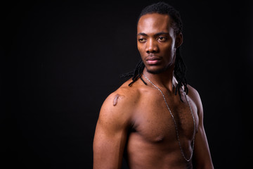 Fototapeta na wymiar Face of young handsome muscular African man with dreadlocks shirtless