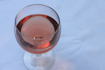 Verre de vin rosé dans un verre ballon transparent sur une nappe blanche - Département du Rhône - France
