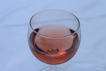Verre de vin rosé dans un verre ballon transparent sur une nappe blanche - Département du Rhône - France