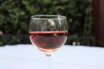 Verre de vin rosé dans un verre ballon transparent sur une nappe blanche - Département du Rhône - France