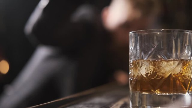a man's hand rolls a glass of whiskey, Bourbon, rum