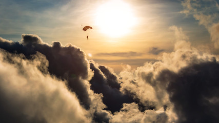 Skydiver above the clouds at sunset