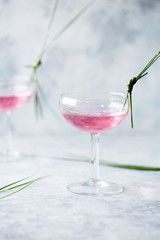 Pink mocktail close up. Beverage with rose and prosecco wine in drinkware. Exotic French Martini cocktail portion with crushed ice in glassware
