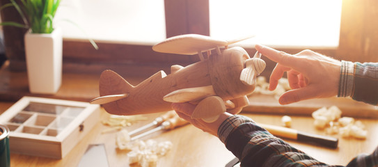 Man playing with an handmade wooden toy airplane