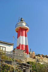 Lighthouse in Tel Aviv coast among industrial trash
