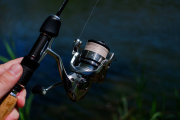 .Spinning the rod against the background of the pond professional tool for fishing a predatory fish on the line