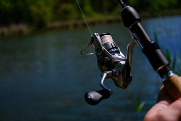 .Spinning the rod against the background of the pond professional tool for fishing a predatory fish on the line