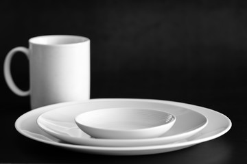 white color Set of plates with cup on black table