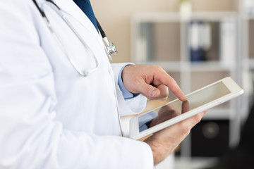 Side view of medical practitioner using digital tablet