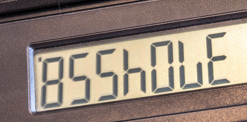 Obraz premium Old LCD calculator display upside down writing out a word asshole