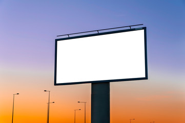 Fototapeta premium Blank white billboard for advertisement near the road at dusk