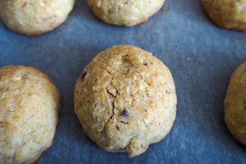 Round gluten-free cookies made of almonds, eggs, butter, sugar, corn and rice flour on parchment paper side view . macro . on a gluten-free diet