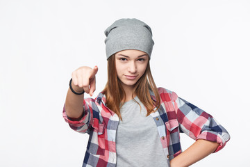 Focused teen girl looking and pointing finger at camera