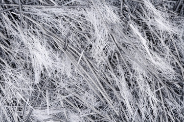 Extreme close up, top down view of a mixture of polypropylene, filament micro fibers and steel, end hooked fibers for concrete structural reinforcement and avoidance of early age cracking problems