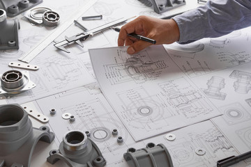 Engineer technician designing drawings mechanical parts engineering Engine.manufacturing factory Industry Industrial work project blueprints measuring bearings caliper tools