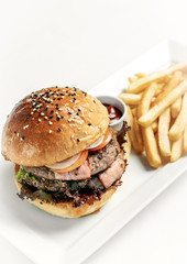 beef burger with french fries platter on white table