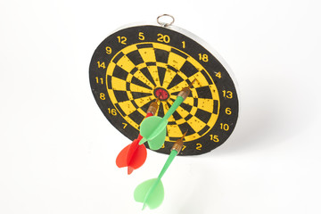 darts target darts all in holes with two green darts and one red on a white background isolate