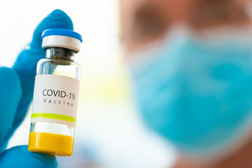 Doctor With Covid-19 Coronavirus Vaccine In Hand. Concept of research with Vaccine for Covid -19 on a research laboratory.
