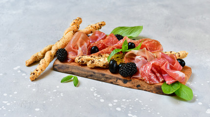 food flat lay italian  antipasti prosciutto, salami, bresaola olives tomatoes and grissini bread...