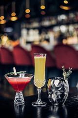 bright cocktail in a beautiful glass neon lighting and plants background
