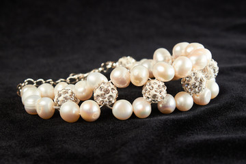 bracelet from pink Mallorca pearls semiprecious stone on black velor. close up