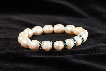 bracelet from pink Mallorca pearls semiprecious stone on black velor. close up