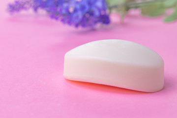 Bars of handmade soap with flowers on the table, close up