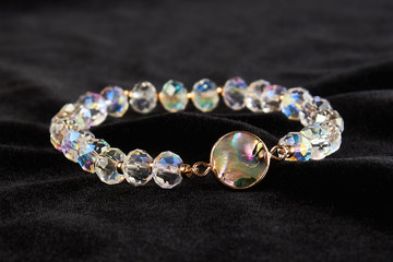 semi-precious stone crystal bracelet on black velor. close up