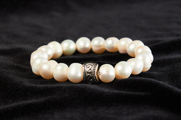 bracelet from pink Mallorca pearls semiprecious stone on black velor. close up