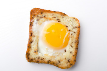 Top view of fresh and tasty egg in the hole on the white background
