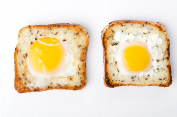 Top view of two slice of bread and fried eggs in it.Tasty eggs in the hole on the white background
