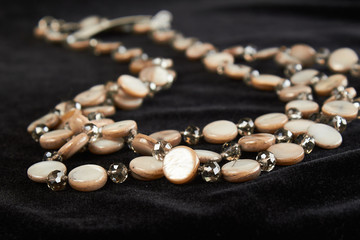 pearl necklace with semi-precious stone on black velor. close up