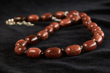 aventurine beads golden sands semiprecious stone on black velor. close up