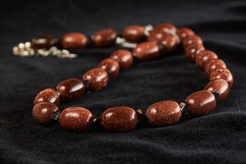 aventurine beads golden sands semiprecious stone on black velor. close up