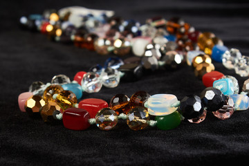 beads from different semiprecious stone on black velor. close up