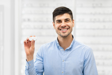 Happy guy holding contact eye lenses container