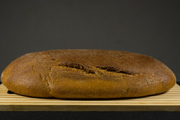 Black bread with sesame seeds. On a wooden