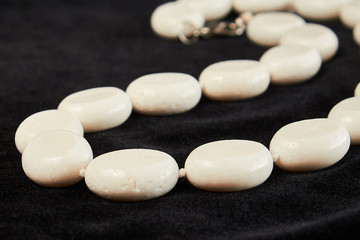Fototapeta na wymiar beads from coral semiprecious stone on black velor. close up