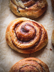 Close up of a cinnamon bun on a baking paper shot from above 