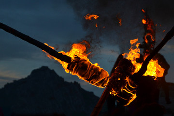 Detail of flames and smoke burning torches. View at dusk, darkness, in the background mountain...
