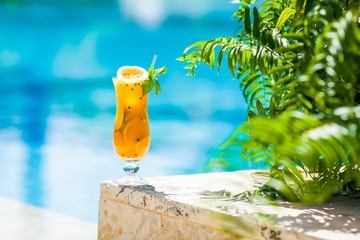 Tropical passion fruit juice alcoholic cocktail standing outdoor in sunlight 