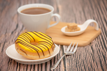 Dessert, Donuts, chocolate and strawberry circles, sugar and cream on Donuts and hot coffee cups, preparation for a break or party on the wooden table background.