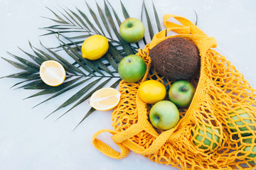 Eco bag string bag with different fruits and a palm branch.