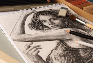 Pencil portrait of a girl and accessories of a graphic artist