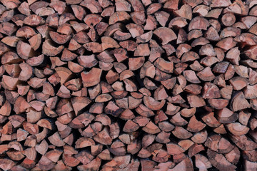 Firewood is stacked in a row, prepared for heating the premises in the cold season.