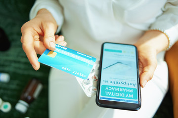 woman buying pharma using phone at home in sunny day