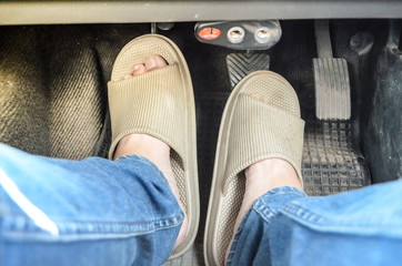 The foots wear slipper stepping on the brake and clutch pedal.