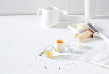 Traditional morning breakfast, boiled eggs, butter, bread, milk, on a white background, modern style

