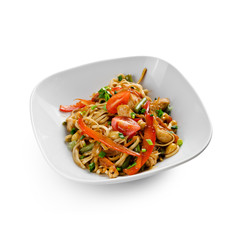 Fried udon noodles in a wok with chicken fillet and green beans. Traditional asian food.